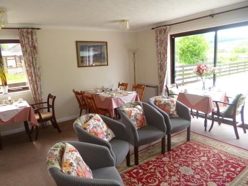 a dining room with tables and chairs and a window at Aslaich in Drumnadrochit