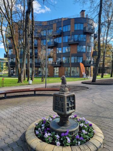a statue in a park in front of a building at MELODIJA apartments in Druskininkai center in Druskininkai