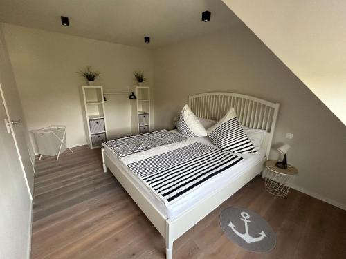 ein Schlafzimmer mit einem weißen Bett und einer Treppe in der Unterkunft Außergewöhnlich Ferienwohnung im Villenviertel in Wilhelmshaven