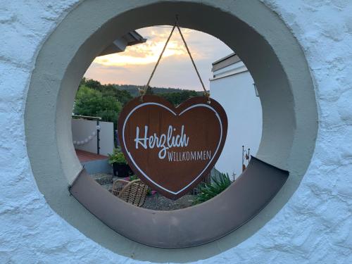 a round window with a heart shaped sign in it at Ferienappartement Albschätzle 