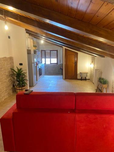 un divano rosso nel mezzo di un soggiorno di Tulipipì a Sant'Albino