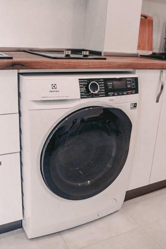 a white washing machine sitting in a kitchen at Apple cozy hotel in Tbilisi City
