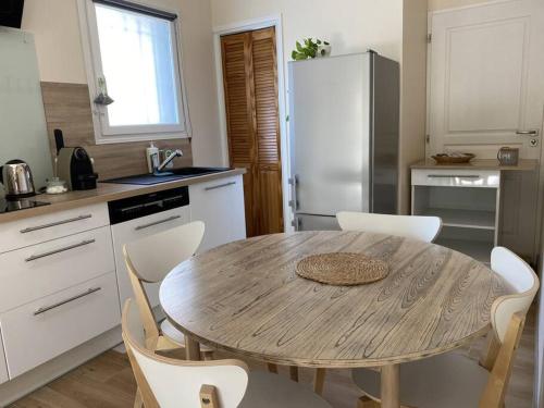 cocina con mesa de madera y electrodomésticos blancos en Appartement climatisé avec terrasse, en Cours la Ville