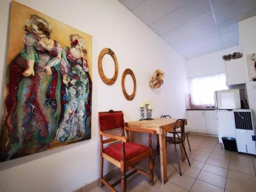 a dining room with a table and a painting on the wall at Leather and Lace & a Suitcase in Groutfontein