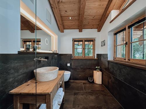 La salle de bains est pourvue d'un lavabo, de toilettes et de fenêtres. dans l'établissement Chalet Alpin mit privatem Whirlpool und Sauna, à Bayrischzell