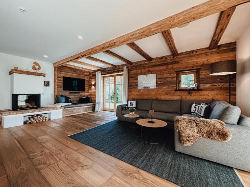 uma sala de estar com um sofá e uma televisão em Chalet Alpin mit privatem Whirlpool und Sauna em Bayrischzell