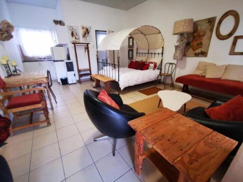 sala de estar con cama, mesa y sillas en Leather and Lace & a Suitcase, en Groutfontein