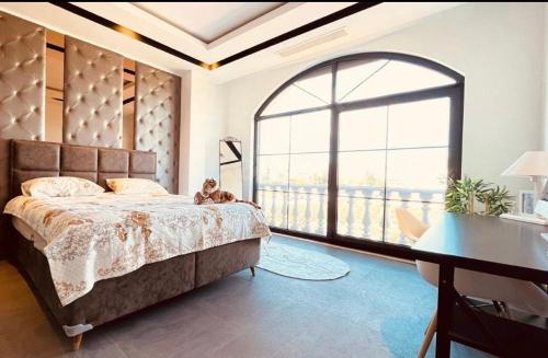 a bedroom with a large bed and a large window at Villa white in Antalya