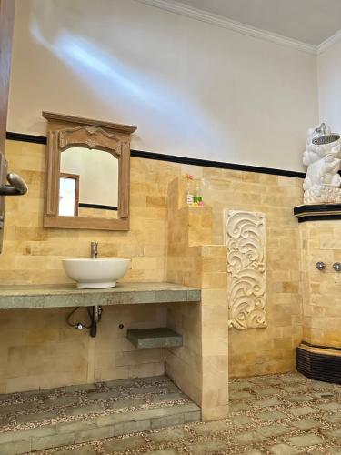 a bathroom with a sink and a mirror at Sanshikirana House Lovina in Lovina