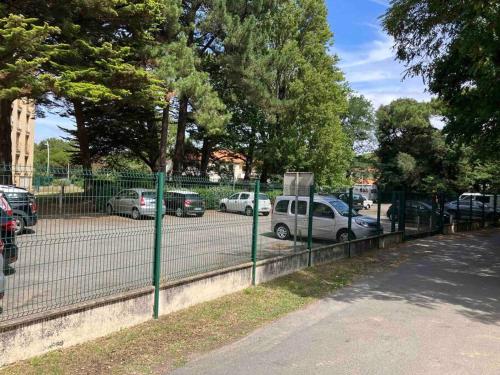 a fence with cars parked in a parking lot at Studio vue sur l’océan in Saint-Brevin-les-Pins