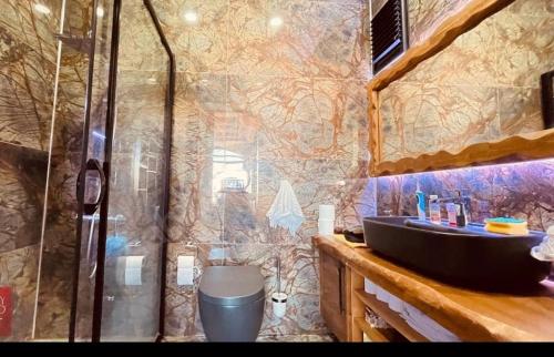 La salle de bains est pourvue d'une douche et d'un lavabo noir. dans l'établissement Villa white, à Antalya