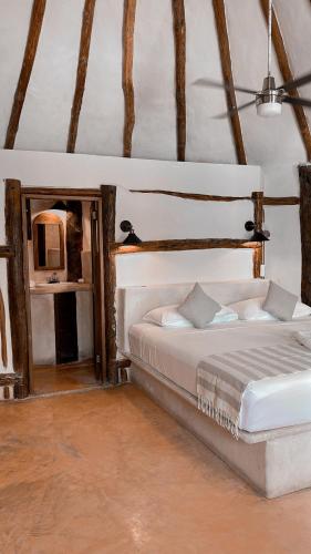 a bedroom with a bed and a mirror at La Conchita Tulum in Tulum