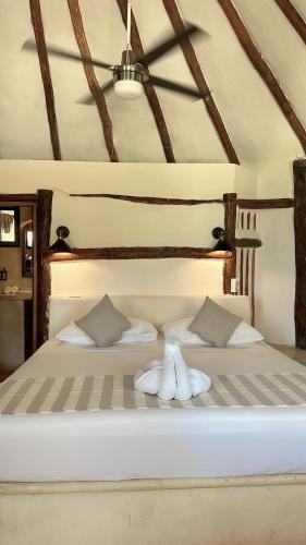 a large white bed with two towels on it at La Conchita Tulum in Tulum