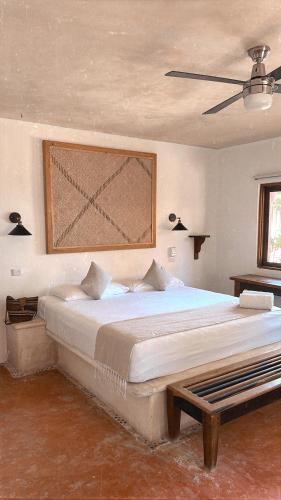 a bedroom with a large bed and a ceiling at La Conchita Tulum in Tulum