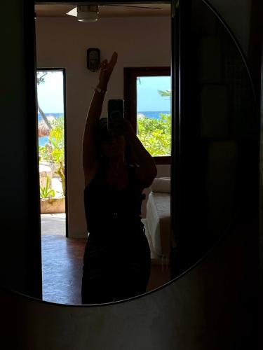 a woman taking a picture of herself in a mirror at La Conchita Tulum in Tulum