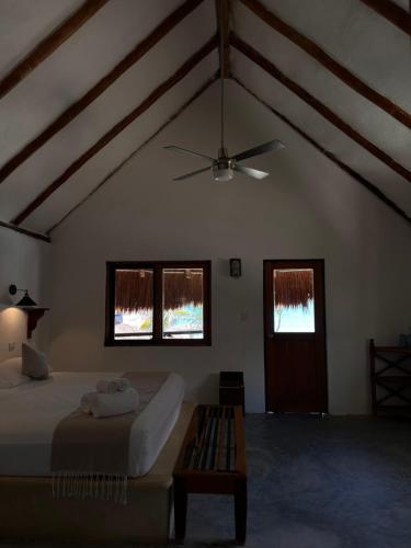 a bedroom with a bed and a ceiling fan at La Conchita Tulum in Tulum