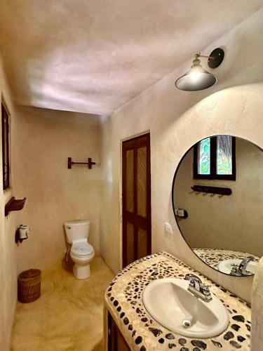 a bathroom with a sink and a mirror at La Conchita Tulum in Tulum