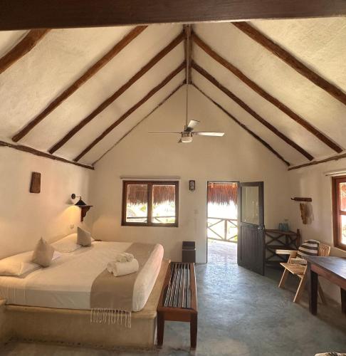 a bedroom with a large bed and a table at La Conchita Tulum in Tulum