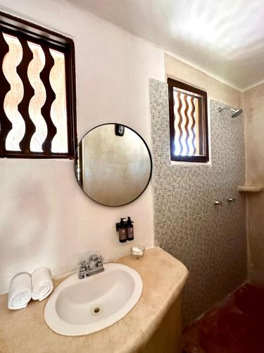 a bathroom with a sink and a mirror at La Conchita Tulum in Tulum