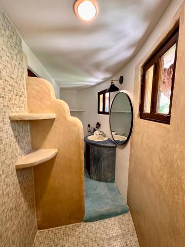 a bathroom with a sink and a mirror at La Conchita Tulum in Tulum