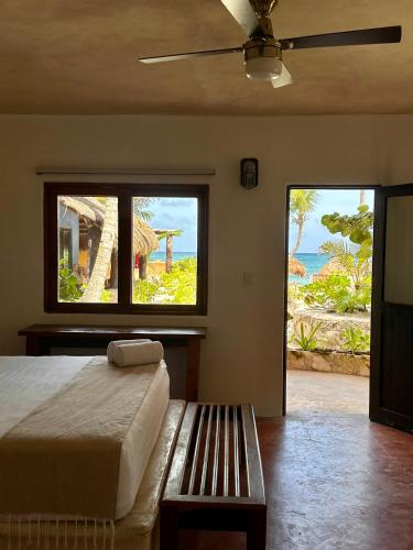a bedroom with a bed and a view of the ocean at La Conchita Tulum in Tulum