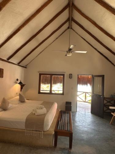a bedroom with a bed and a bench in a room at La Conchita Tulum in Tulum
