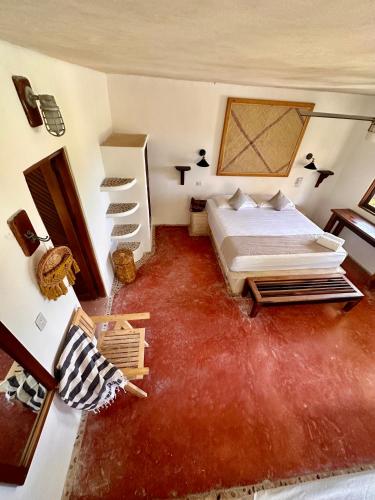 a bedroom with a bed and a red carpet at La Conchita Tulum in Tulum