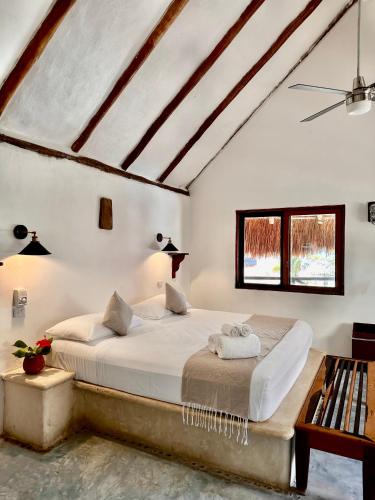 a bedroom with white walls and a large bed at La Conchita Tulum in Tulum
