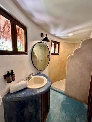 a bathroom with a sink and a tub at La Conchita Tulum in Tulum