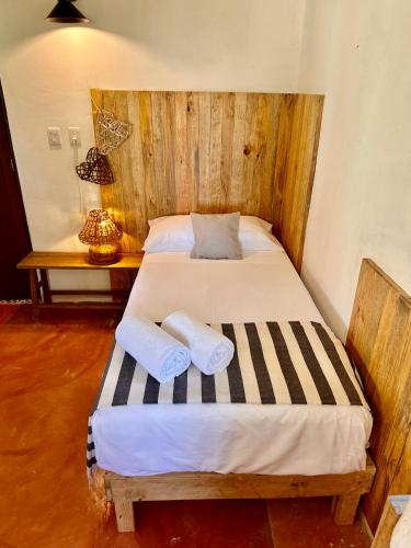 a bedroom with a bed with two towels on it at La Conchita Tulum in Tulum