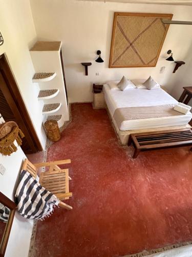 a bedroom with a bed and a red carpet at La Conchita Tulum in Tulum