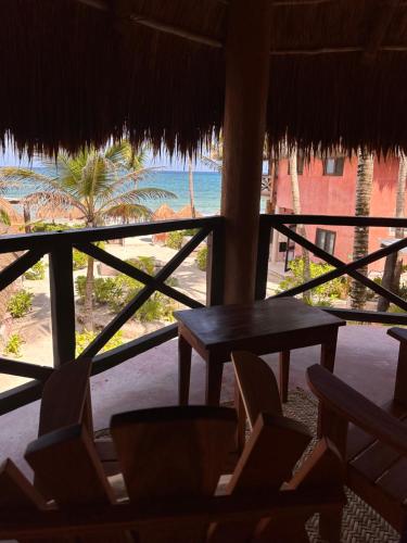 a table and chairs in a room with a view of the ocean at La Conchita Tulum in Tulum