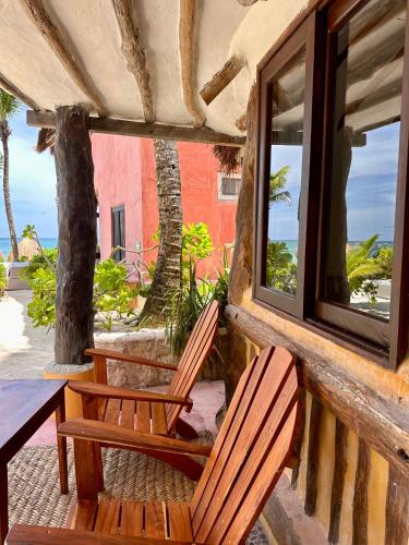 two chairs sitting on a porch with a window at La Conchita Tulum in Tulum