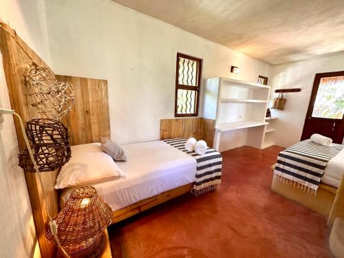 a bedroom with two beds and a window at La Conchita Tulum in Tulum