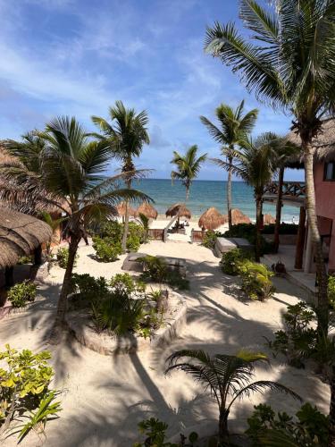 a view of a beach with palm trees and the ocean at La Conchita Tulum in Tulum