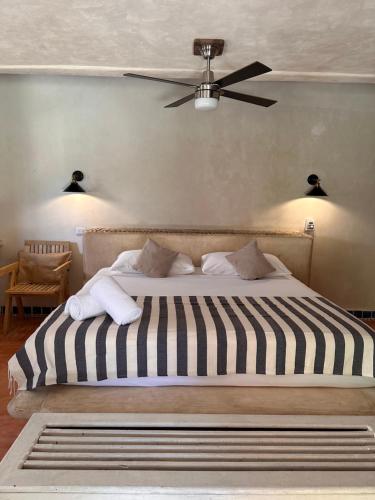 a bedroom with a black and white bed with a ceiling fan at La Conchita Tulum in Tulum