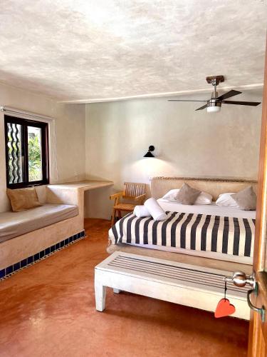 a bedroom with two beds and a window at La Conchita Tulum in Tulum