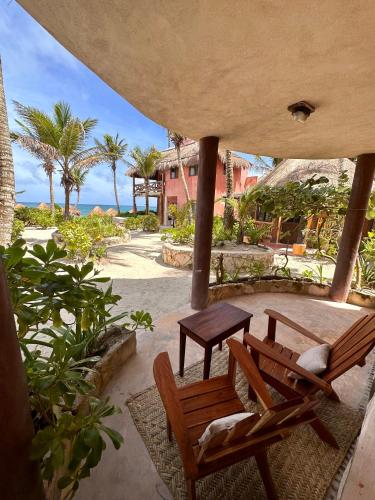 a patio with two wooden chairs and a table at La Conchita Tulum in Tulum