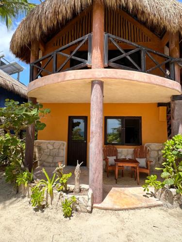 a house on the beach with a straw roof at La Conchita Tulum in Tulum