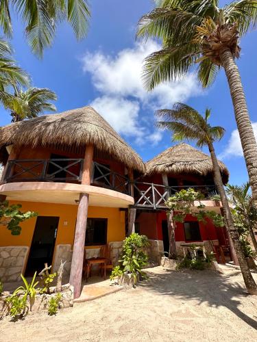 a house on the beach with two palm trees at La Conchita Tulum in Tulum