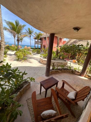 two chairs and a table on a patio with the ocean at La Conchita Tulum in Tulum