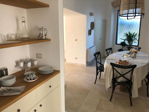a kitchen and a dining room with a table at Dimora Caraspi in Mola di Bari