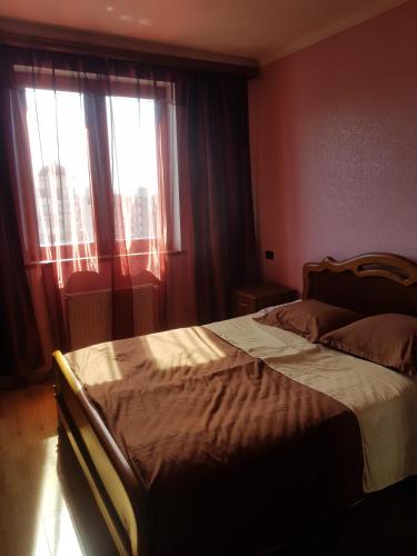 una camera da letto con un letto grande con una finestra di Isani Panorama a Tbilisi City