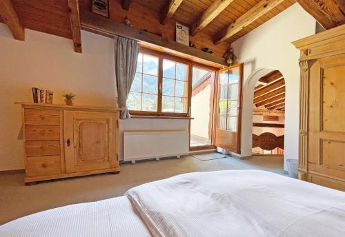 a bedroom with a bed and a large window at Holiday flat with Jacuzzi for 6 persons-Lenzerheide in Lenzerheide