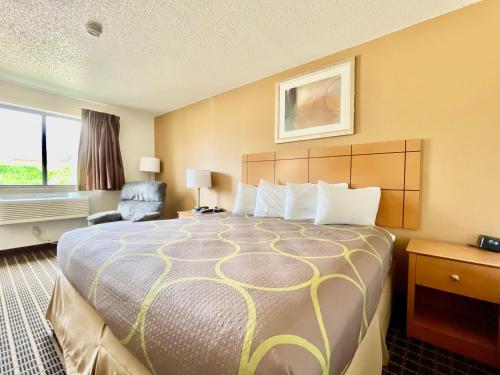 a hotel room with a large bed and a window at The Quincy Inn & Suites in Quincy