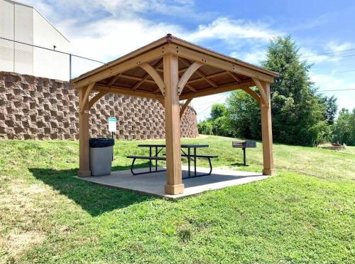 a wooden pavilion with a picnic table in a field at The Quincy Inn & Suites in Quincy