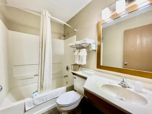 y baño con lavabo, aseo y espejo. en The Quincy Inn & Suites, en Quincy