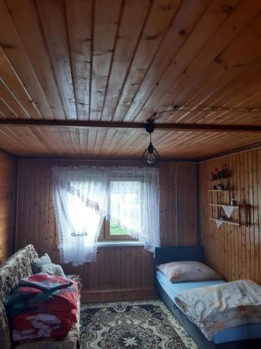 a room with two beds and a window in a house at Domek w górach Wioletta in Rycerka Górna