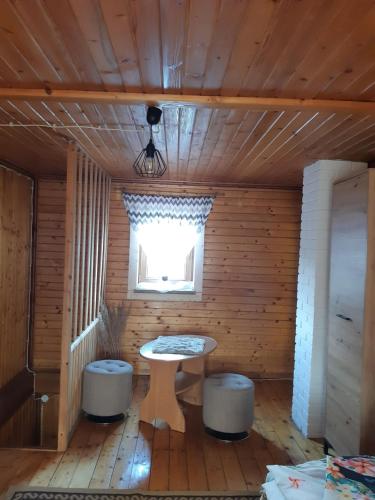 a room with a table and two stools in a cabin at Domek w górach Wioletta in Rycerka Górna