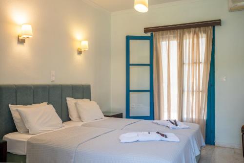 two beds in a hotel room with towels on them at Karavostasi Beach Hotel in Perdika